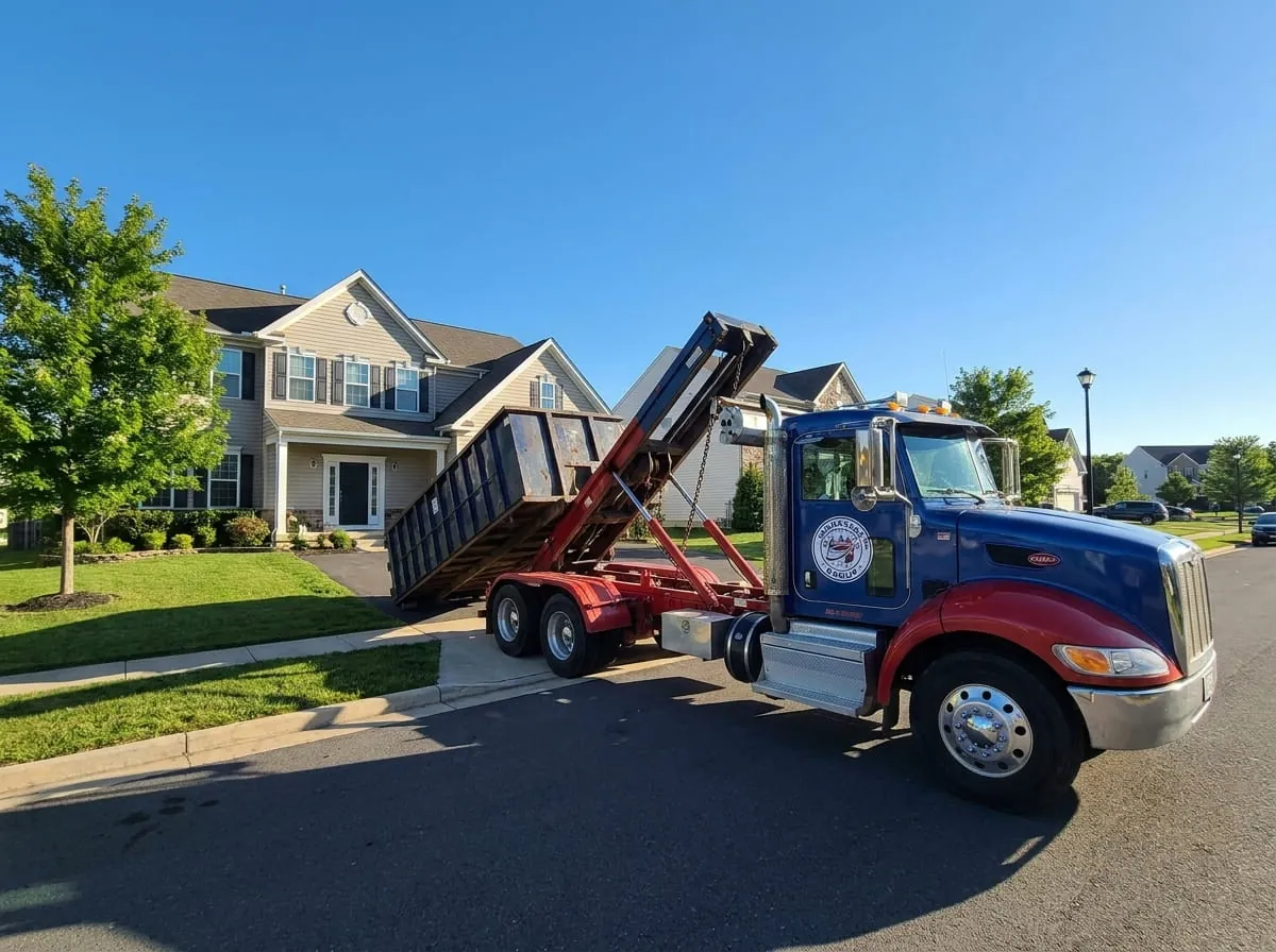 Same-day dumpster delivery in Manassas, VA Manassas Dumpster Rental Group truck delivering a roll-off dumpster to a Manassas VA driveway
